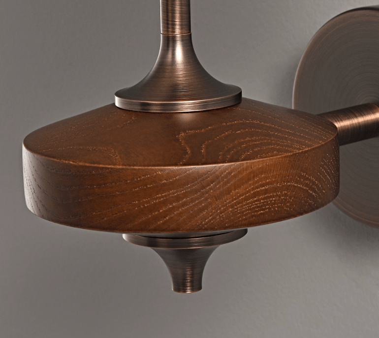 Close view of the grained walnut wood disc, bronze collar and tapering finial on this Clérachic wall sconce.