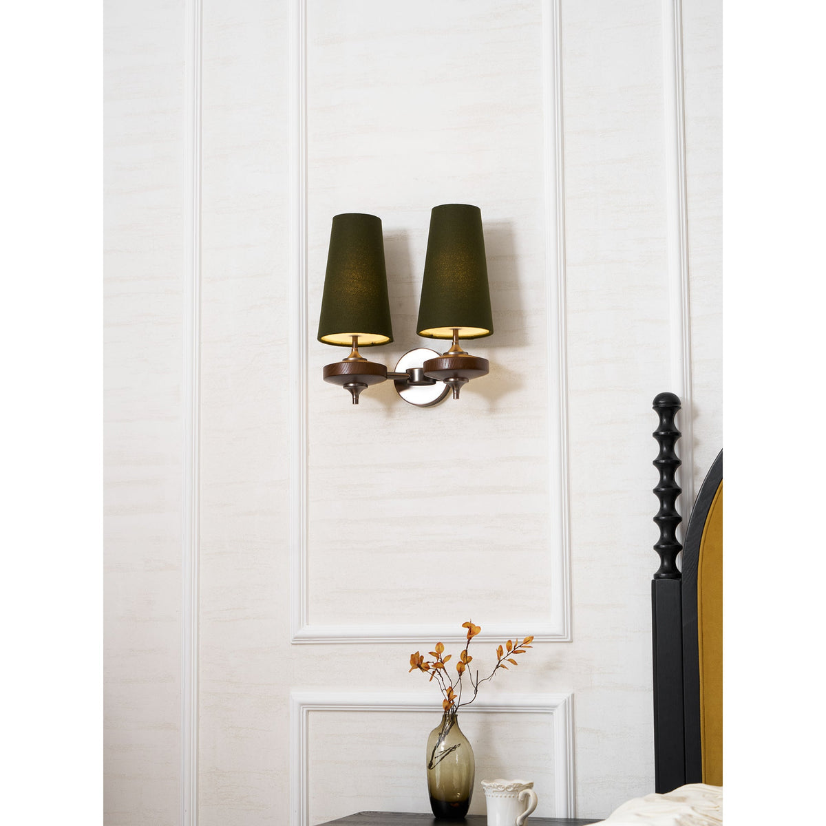 Lit green shades on a Clérachic twin wall light with a polished silver-toned backplate, on a white panelled wall.