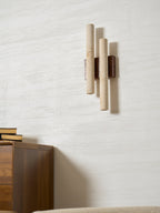 Seen from the side, this unlit Clérachic wall light shows its two stone tubes standing off a white textured wall.