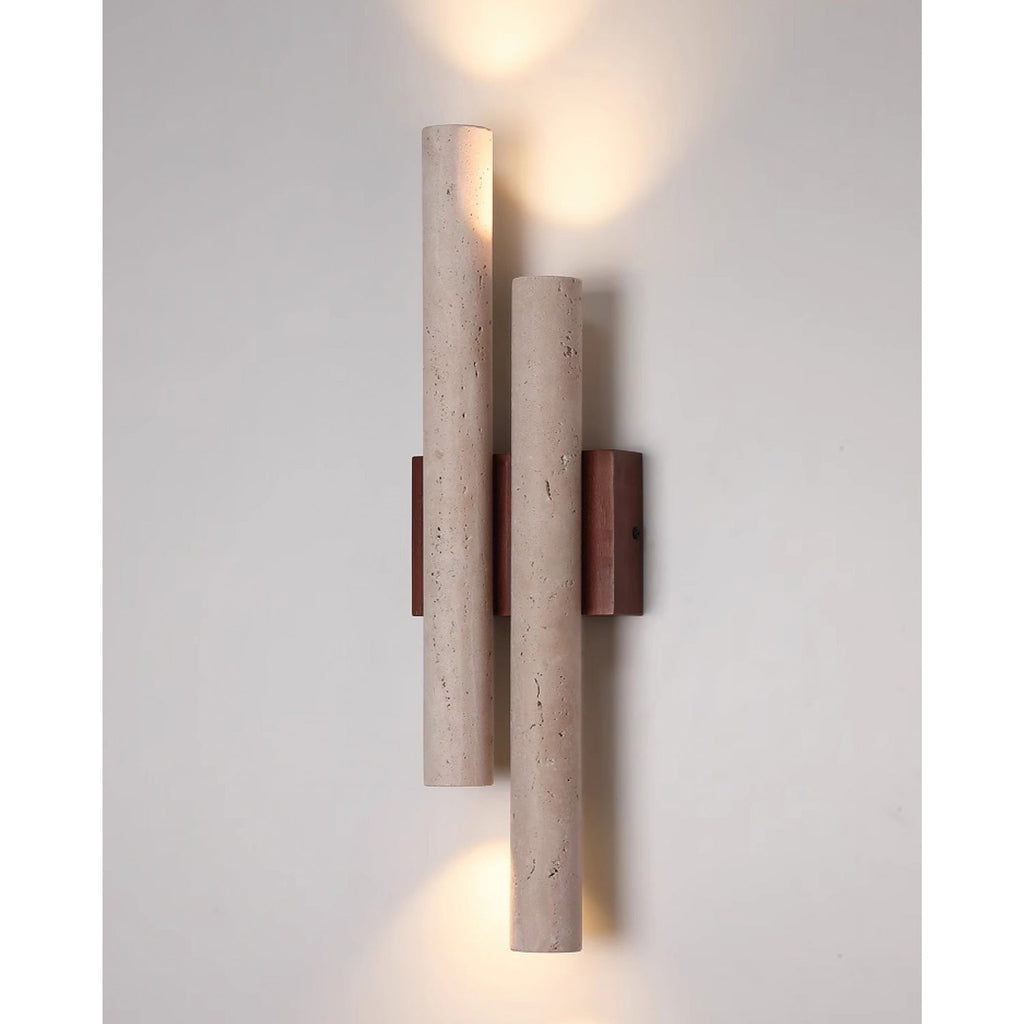 This Clérachic wall light is lit above and below, casting light along a pale grey wall from its two stone tubes.
