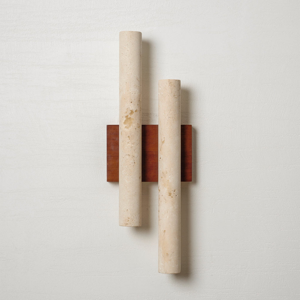 Straight-on view of this Clérachic wall light: two pale travertine tubes, one taller than the other, on a walnut plate.