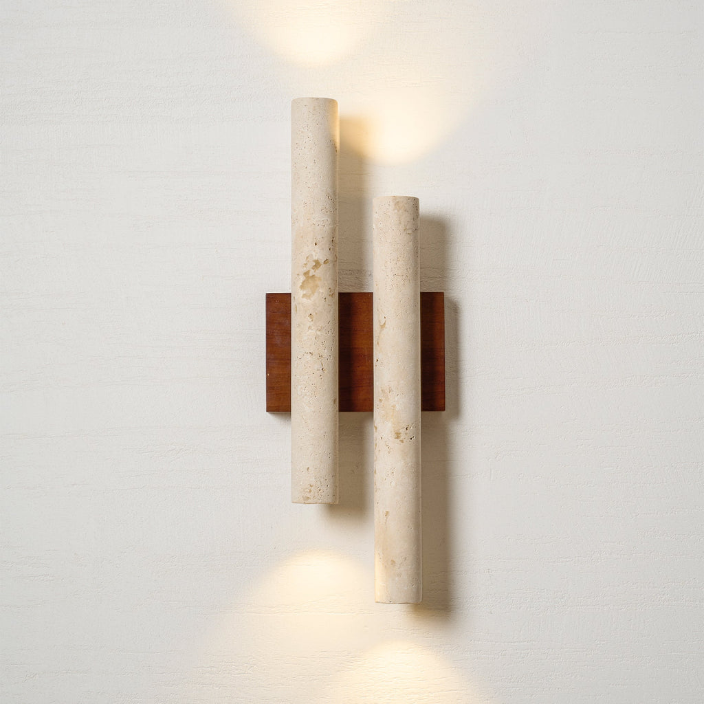 Lit Clérachic wall light on a white wall, with warm light thrown above the top tube and below the lower one.