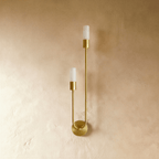 Clérachic brass wall light switched off, two frosted cylindrical diffusers on brass sockets above a round wall plate.