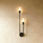 Clérachic black wall light, mirrored version, with two lit frosted cylinder diffusers at different heights on a thin arm.