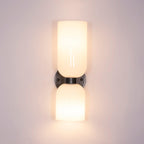 Lit against a lavender wall, the opal shades on this gunmetal Clérachic sconce cast a warm glow.
