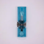 Blue glass cylinders trace this matt black Clérachic wall light against a soft lilac backdrop.