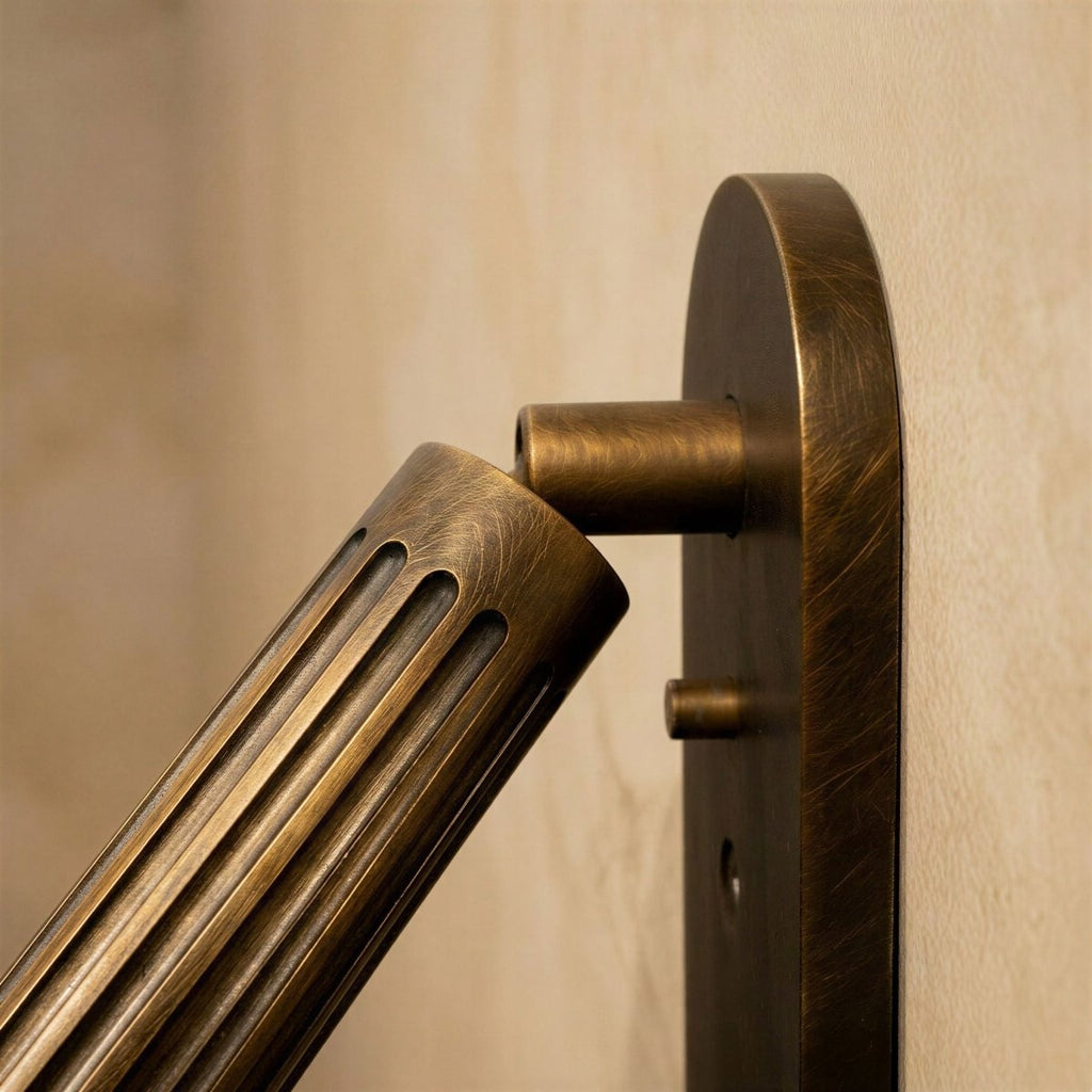Side detail of the Clérachic fluted brass cylinder head tilting on its pivot arm from a flat oval backplate