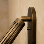 Side detail of the Clérachic fluted brass cylinder head tilting on its pivot arm from a flat oval backplate