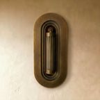 Clérachic embedded brass wall light with its fluted cylinder folded flat inside a stepped oval recess