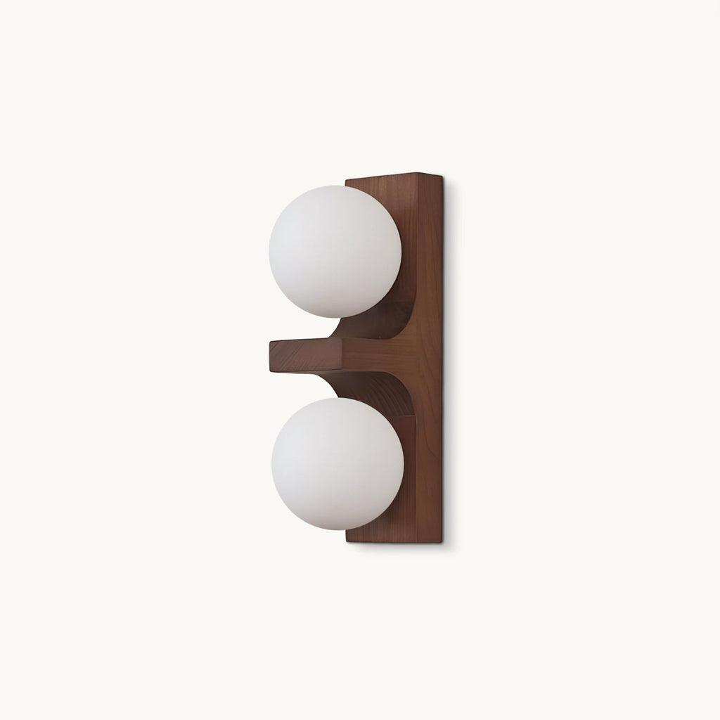 On a plain white backdrop, a compact Clérachic wall light with a walnut-coloured wood backplate and two round frosted white glass globes.
