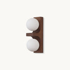 On a plain white backdrop, a compact Clérachic wall light with a walnut-coloured wood backplate and two round frosted white glass globes.