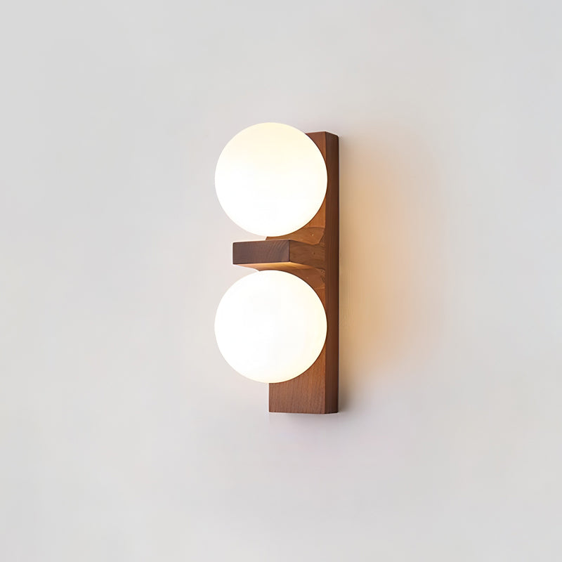 A compact Clérachic wall light with a wide walnut-coloured plate, a small wooden shelf and two softly glowing globes.