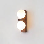 A compact Clérachic wall light with a wide walnut-coloured plate, a small wooden shelf and two softly glowing globes.