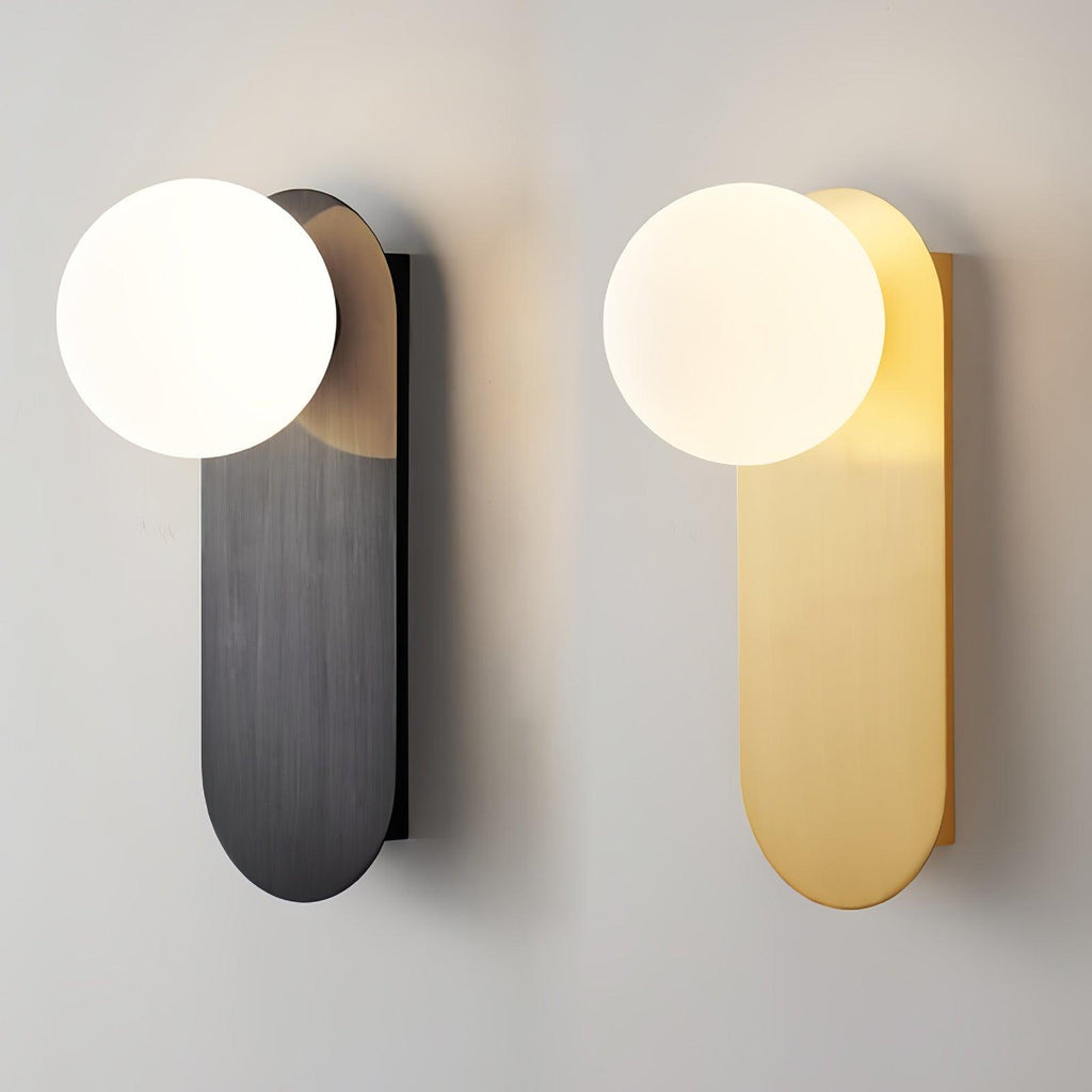 Black and brass versions of this Clérachic globe wall light side by side on a pale wall, both with lit white globes.