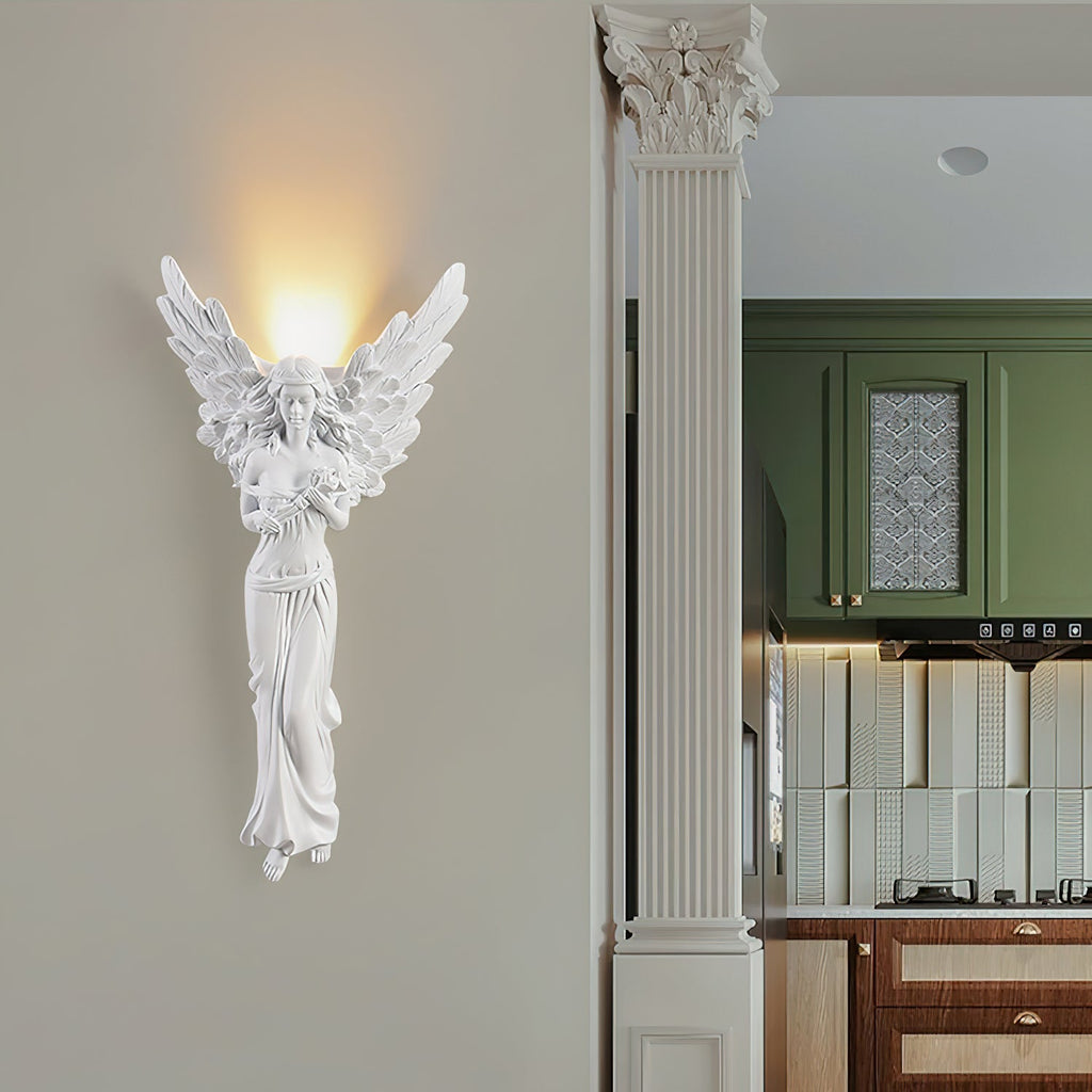 Standing-angel Clérachic wall light lit beside a fluted column, with a green kitchen visible through the open doorway.