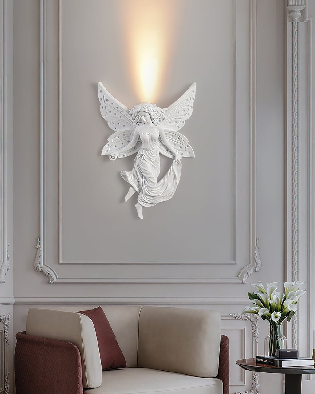 Lit fairy Clérachic wall light on a panelled wall above an armchair with a burgundy cushion and a vase of white flowers.
