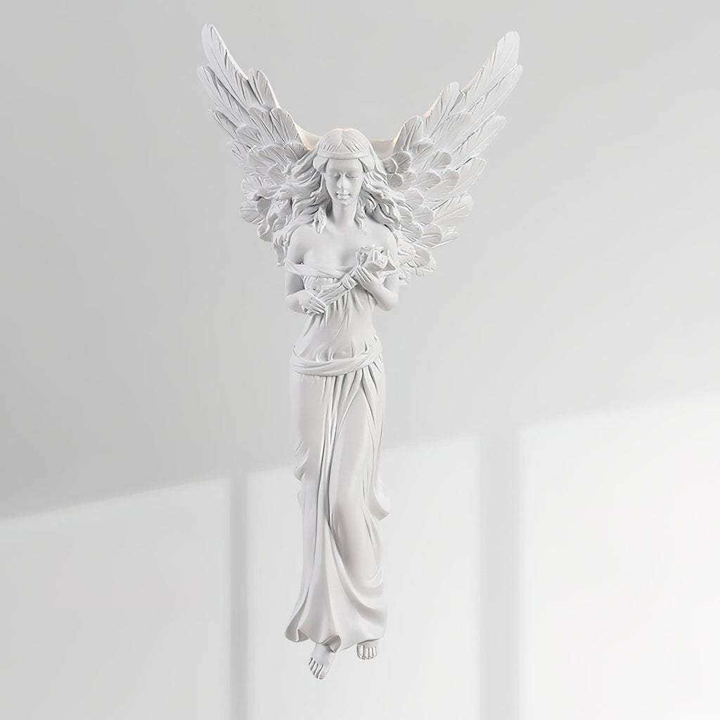 Unlit standing-angel Clérachic wall light on a sunlit white wall, its feathered wings and draped gown in white resin.