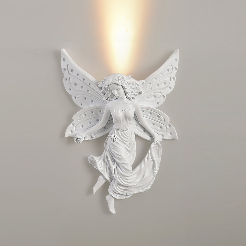 Fairy Clérachic wall light on a grey wall, lit, with a strong column of warm light rising above its butterfly wings.
