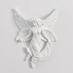 Unlit fairy-shaped Clérachic wall light on a pale wall, its perforated butterfly wings and flowing skirt in white resin.