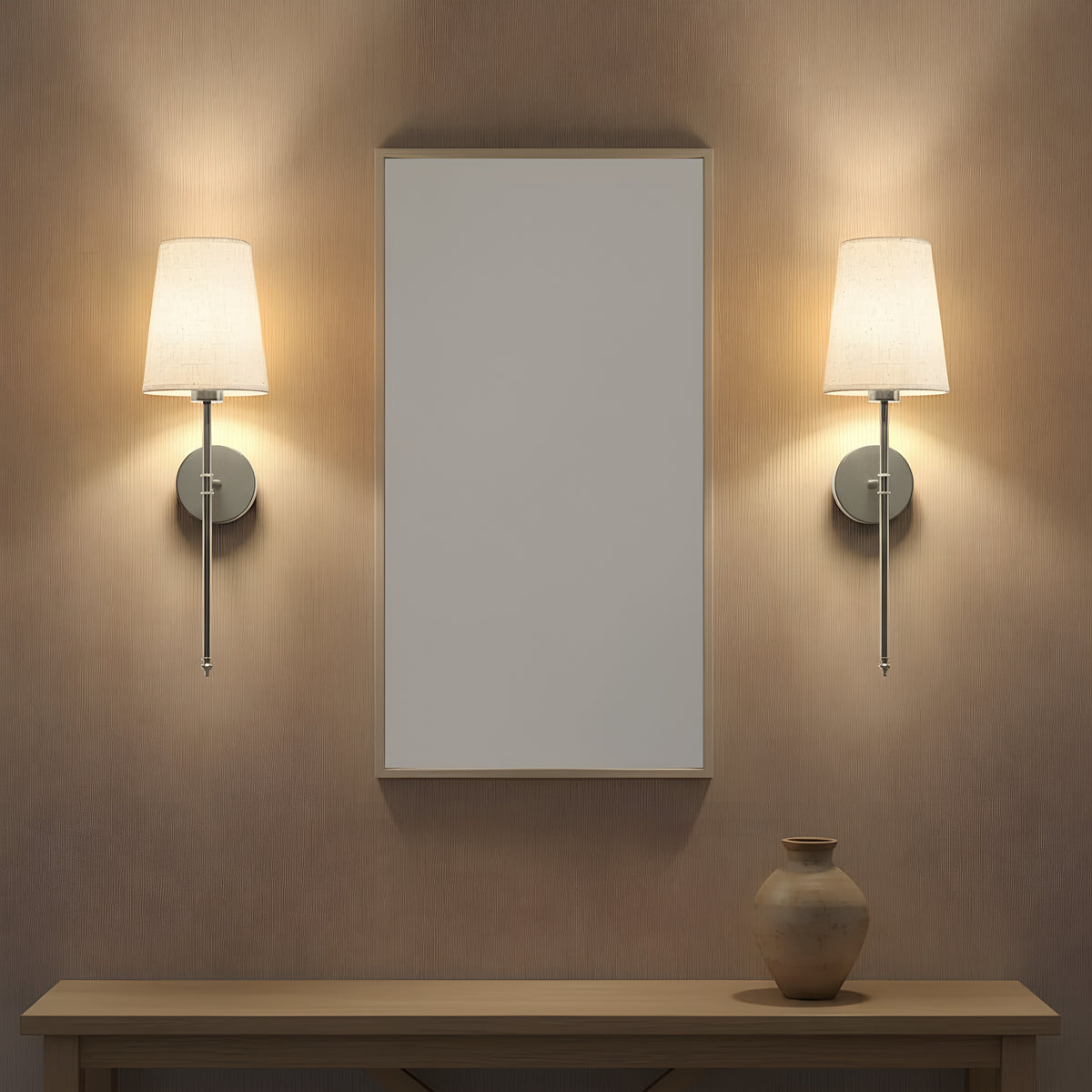 The brushed silver sconce pair either side of a hallway mirror above a console table, lit at a neutral white