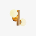 Slightly angled view of this Clérachic wood sconce, its two glass globes glowing softly on a plain light background.