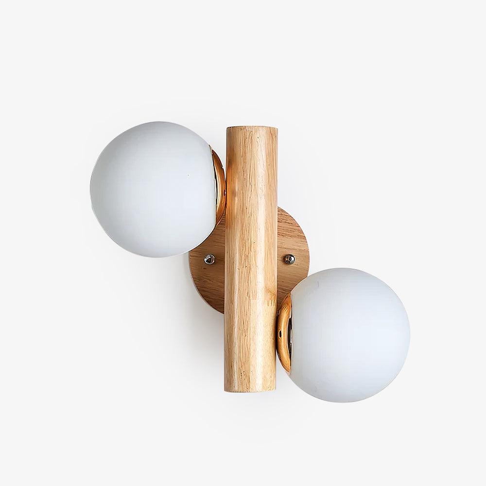 Front view of this Clérachic wall sconce on a white wall, with its round wooden backplate and two white glass globes.