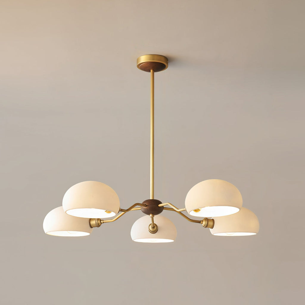 The five-light version of this Clérachic chandelier, its white shades lit from inside on a warm grey wall.