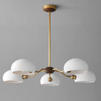 Five white ceramic shades on brass arms, a Clérachic chandelier with a walnut and brass canopy against a cool grey wall.