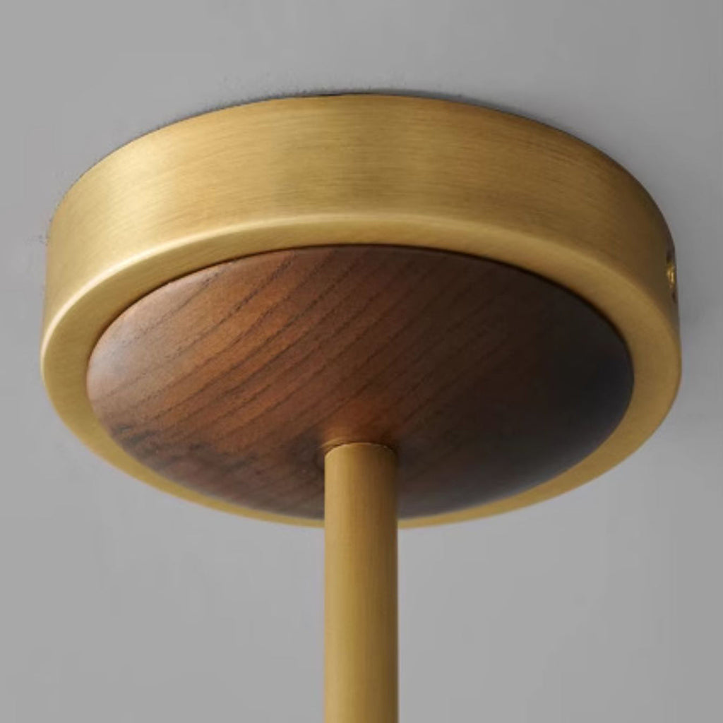 Close view of the antique brass ceiling canopy with a walnut centre on this Clérachic chandelier, and the rod below it.