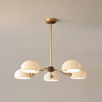 Warm light inside the five white shades of this Clérachic chandelier, shown against a soft beige wall.