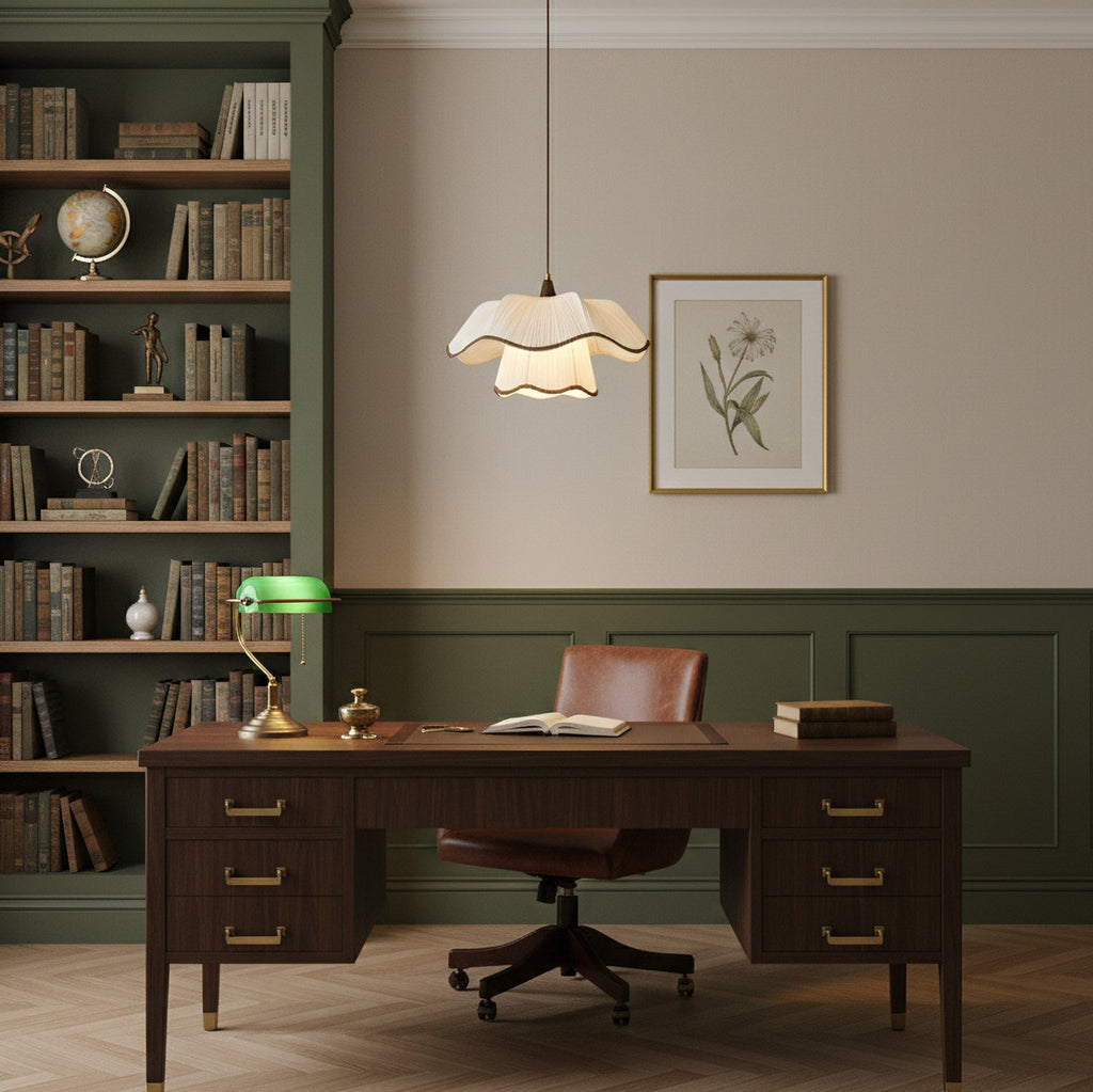 Small Clérachic pendant with a scalloped white shade in a study, above a dark wooden desk with a green banker's lamp and a leather chair.