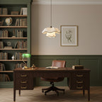 Small Clérachic pendant with a scalloped white shade in a study, above a dark wooden desk with a green banker's lamp and a leather chair.