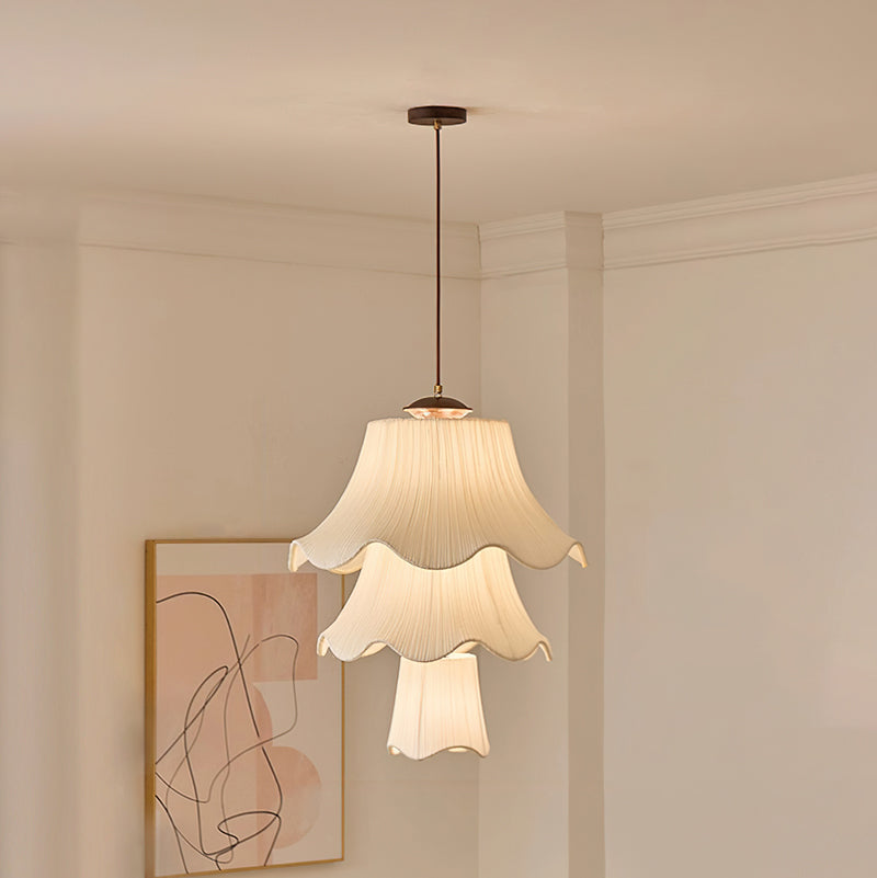 Tall three-tier version of this Clérachic pendant lit in a corner with cornice moulding, beside a framed abstract line drawing.