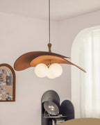Brown Clérachic pendant seen from further back, hung near an arched pinboard and a curtained window with a black shelf below.
