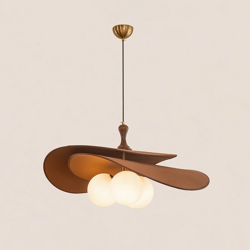 Brown version of this Clérachic pendant on a soft beige backdrop, with a brass ceiling cup, black cord and three lit opal globes.