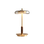 Unlit Clérachic table lamp against white, showing the glass dish shade, slim brass stem, walnut grip and flat round base.