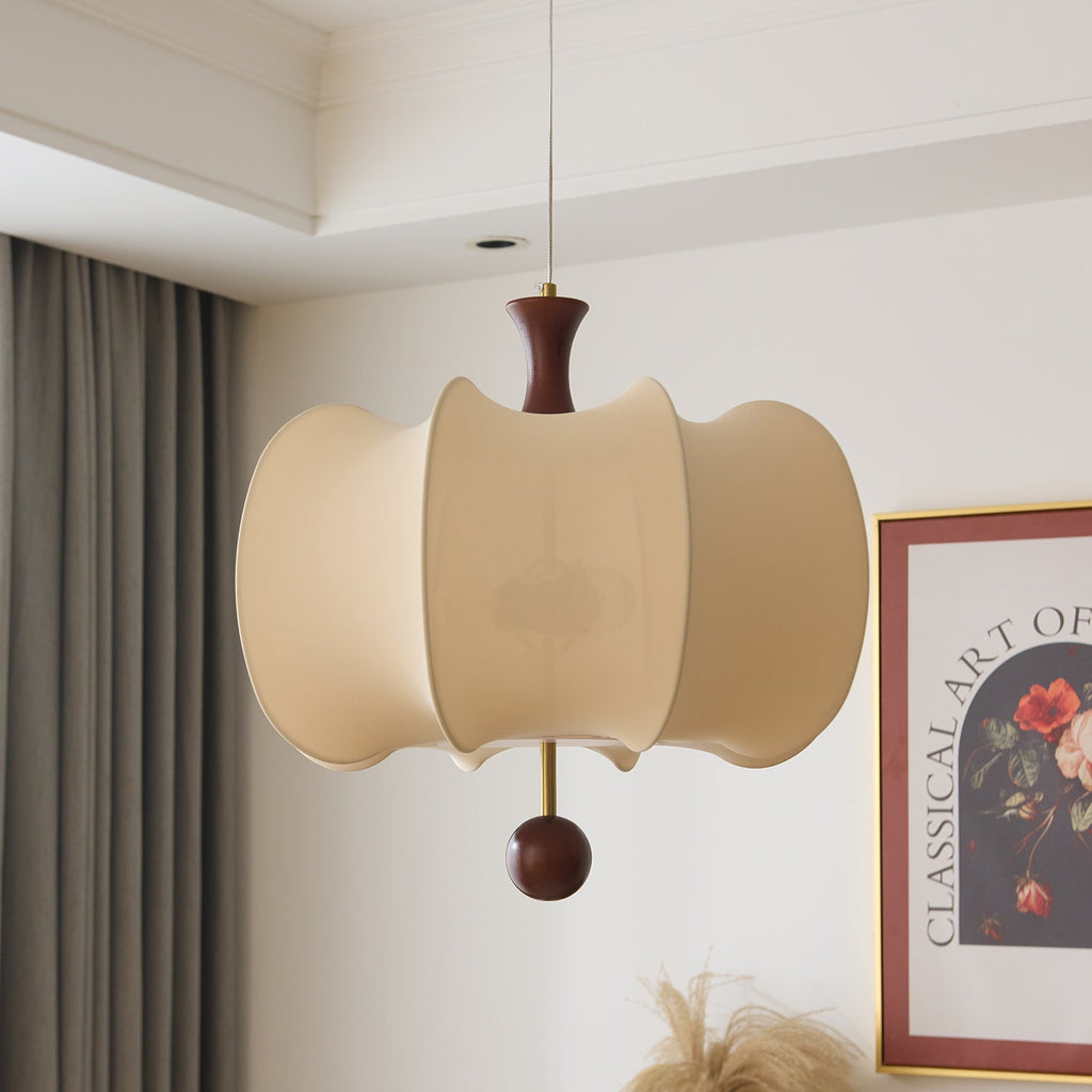 Clérachic petal-shell pendant light unlit against a pale corniced wall, its shells reading flat beige beside a curtain and a cropped floral print.