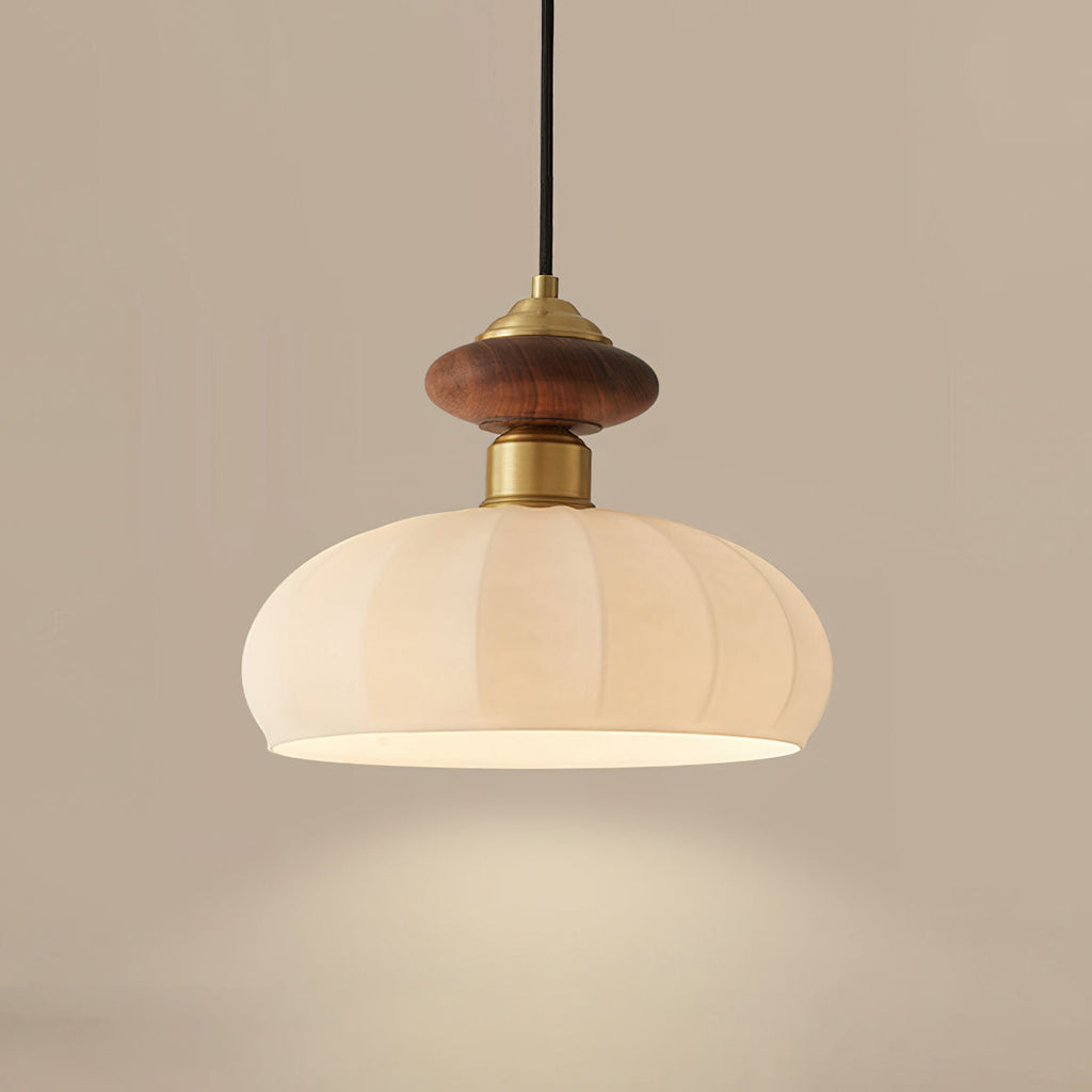 Close view of this Clérachic pendant, showing the walnut-coloured knob, brass collar and softly lit ribbed glass shade.