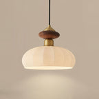 Close view of this Clérachic pendant, showing the walnut-coloured knob, brass collar and softly lit ribbed glass shade.