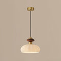 Unlit Clérachic pendant with a ribbed glass shade, walnut-coloured knob and brass canopy, on a warm taupe backdrop.