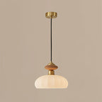 The same Clérachic pendant lit on a taupe backdrop, the ribbed glass shade glowing warm beneath the wooden and brass top.