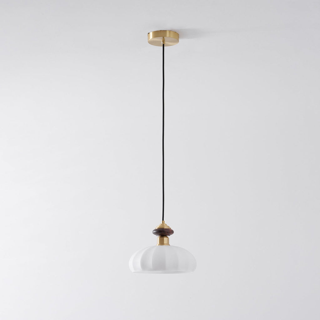 Full-length view of this Clérachic pendant, from its brass ceiling plate and black cord to the ribbed white glass shade.