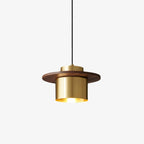 Clérachic pendant with a brass cylinder shade and a flat walnut disc, hung on a black cord against a plain white backdrop.
