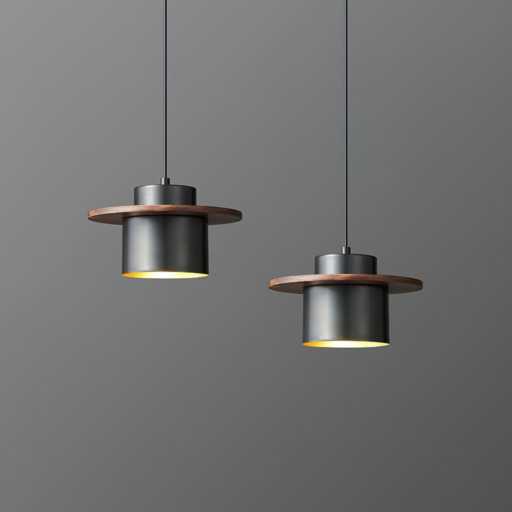 Two black-and-walnut Clérachic pendants hang at different heights, with a warm brass interior visible beneath each shade.