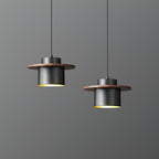 Two black-and-walnut Clérachic pendants hang at different heights, with a warm brass interior visible beneath each shade.