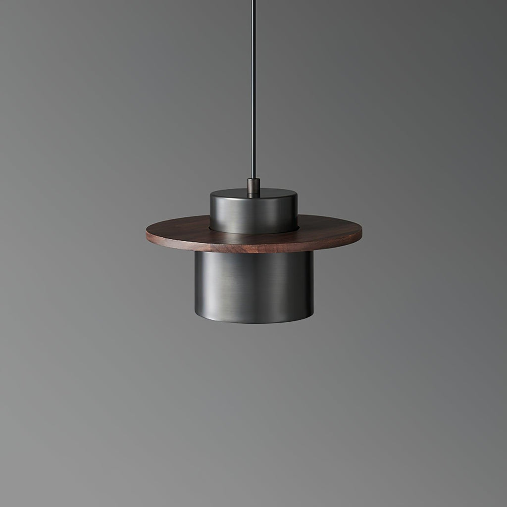 Front view of a black-and-walnut Clérachic pendant, its dark metal cylinder under a round walnut brim, on a grey backdrop.