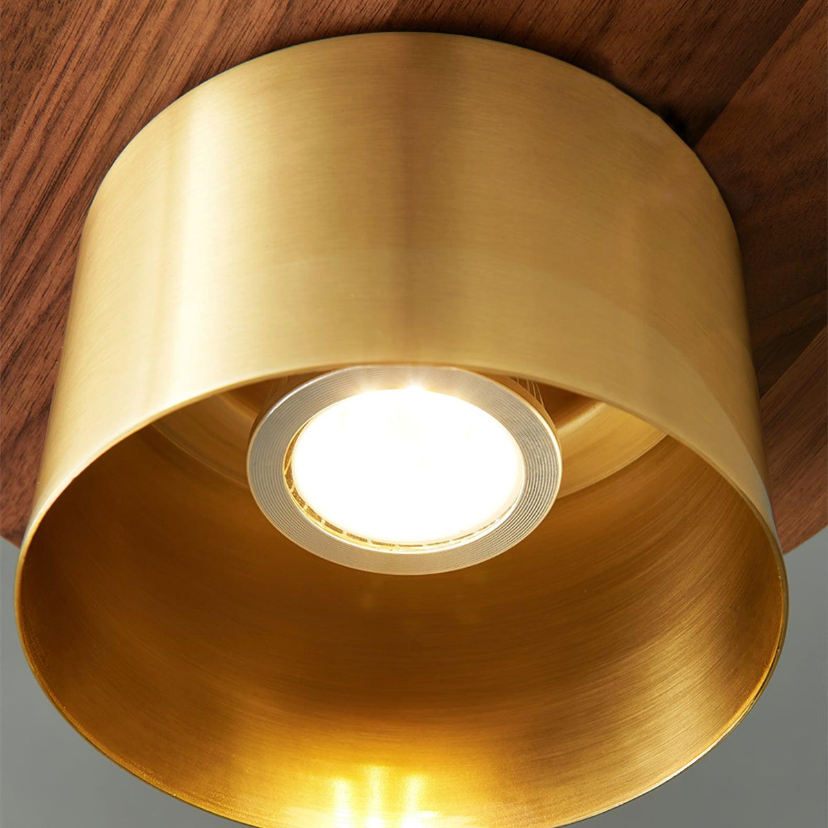 Looking up into the brass shade of this Clérachic pendant, with a ring-mounted bulb lit inside a warm brass interior.