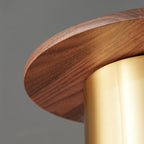Close view of the walnut grain along the brim of this Clérachic pendant, where it meets the brass cylinder.