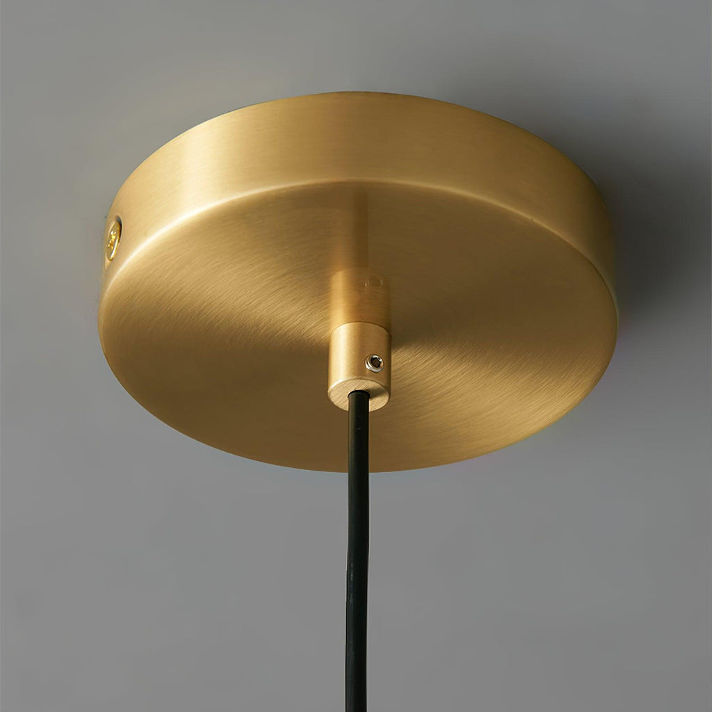 Close view of the brushed brass ceiling canopy and black cord entry on this Clérachic pendant.