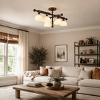 A Clérachic semi flush ceiling light over a living room with a cream sofa, a rustic wood coffee table and a leafy plant.